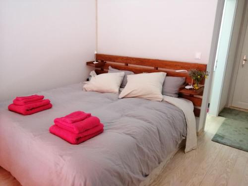 a bed with two red towels on top of it at LES JARDINS CELESTES in Saint-Genest-de-Bauzon