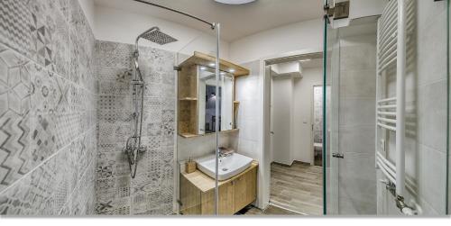 een badkamer met een wastafel en een glazen douche bij Duna Aréna Boutique Apartment in Boedapest