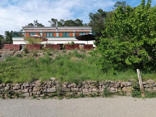 a house on top of a hill with a stone wall at LES JARDINS CELESTES in Saint-Genest-de-Bauzon