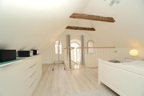 a kitchen with white walls and wooden floors at Tischlerhaus - Ferienhaus am Schleswiger Dom in Schleswig
