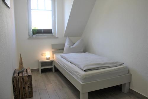 - une petite chambre avec un lit et une fenêtre dans l'établissement Meerblick, à Timmendorfer Strand