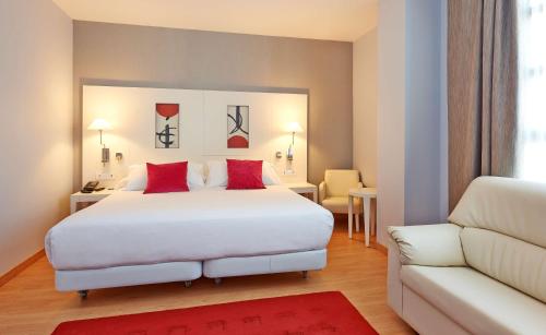 a hotel room with a white bed and white walls at NH Valencia Las Artes in Valencia