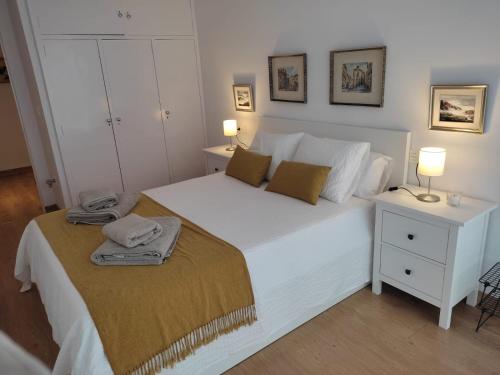 a bedroom with a white bed with two lamps on it at Ría de Navia in Navia