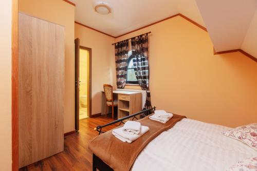a bedroom with a bed with two towels on it at Penzion Kersko in Hradišťko