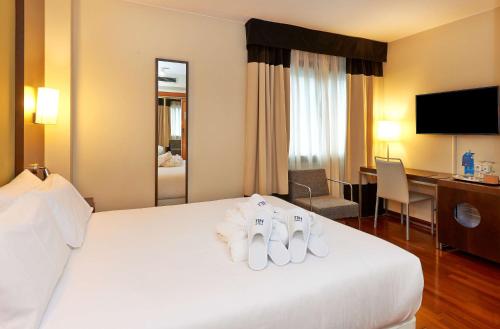 une chambre d'hôtel avec un lit et des serviettes. dans l'établissement NH Sport, à Saragosse