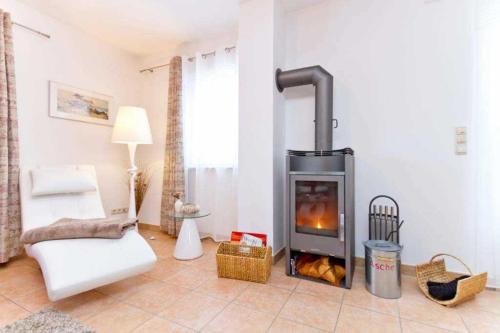 a living room with a fireplace and a couch at Ferienhaus Reethaus Koserow in Ostseebad Koserow