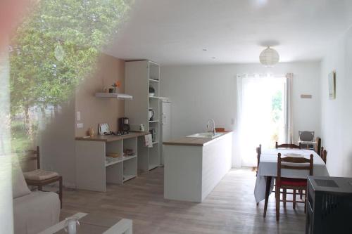 una cucina e un soggiorno con tavolo, cucina e sala da pranzo di Gîte de Maran 1 - Le Nid Douillet a Gaugeac