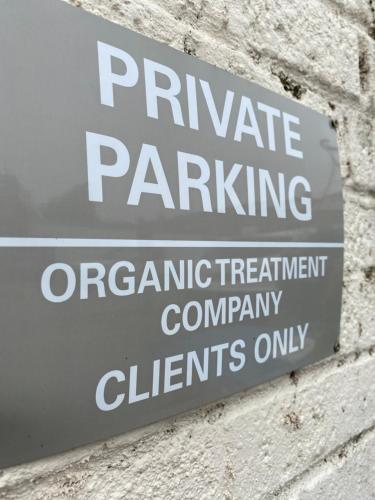 a sign for private parking on a brick wall at Cosy one bed central Fareham in Fareham