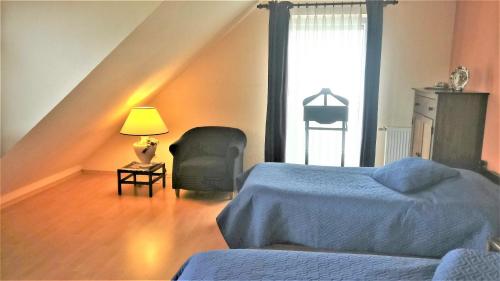 een slaapkamer met een bed, een lamp en een raam bij B&B Grenspaal 286 in Hillensberg