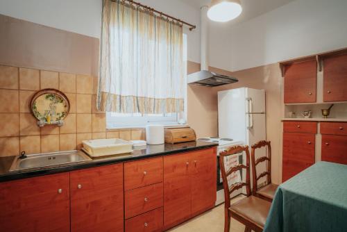 a kitchen with wooden cabinets and a sink and a window at Kalavrita downtown 3 bedroom house for 6 pers in Kalavrita