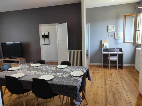 une salle à manger avec une table et des chaises et une cuisine dans l'établissement Bonheur and Co, à Espalion