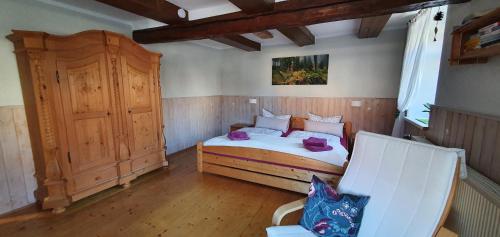 a bedroom with a bed and a wooden cabinet at Ferienwohnung Zur Ellernmühle in Bad Suderode