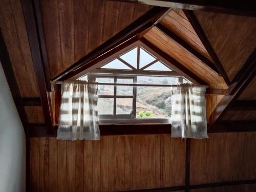 a window in a room with a wooden wall at Cabañita con cocineta y vista a la montaña in San Pablo Etla