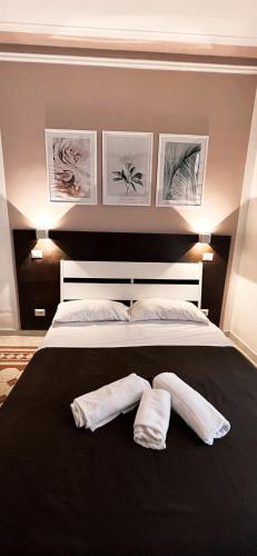 ローマにあるNova Roma Guest Houseの大型ベッド1台(白いタオル2枚付)