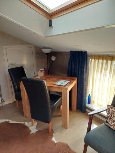 a room with a wooden table and two chairs at Boerderij Hazenveld in Kockengen