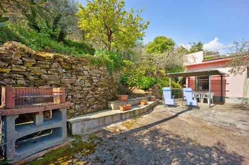a backyard with a stone wall and a stone oven at Casetta Antonella in Lecchiore