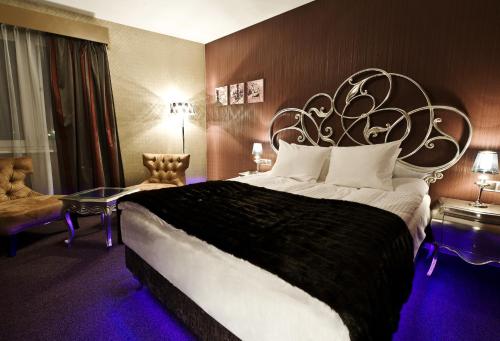 a bedroom with a large bed with a large headboard at Hotel 3 Trio in Białystok