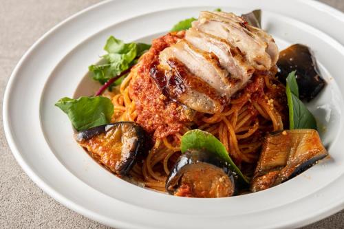 a plate of pasta with meat and vegetables on a table at Hotel LOVE JEWEL in Kitakyushu