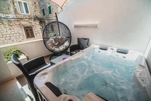 a jacuzzi tub on a balcony with chairs at Downtown Luxury Apartments with Hot Tub in Vodice