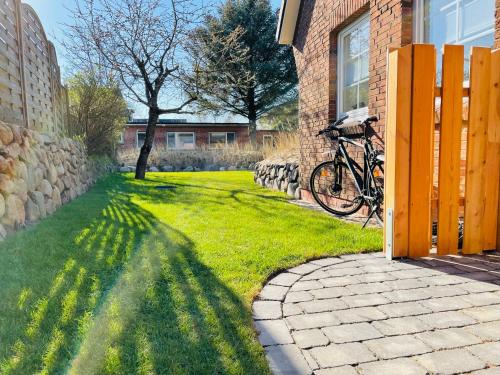 a bike parked next to a brick building with a yard at Sylt Seascape III in Tinnum