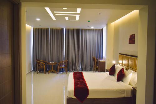 a bedroom with a bed and a table and chairs at Pearl Palace in Attingal
