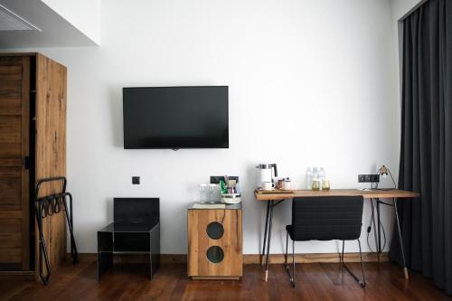a room with a table and a television on a wall at Shota @ Rustaveli Boutique Hotel in Tbilisi City