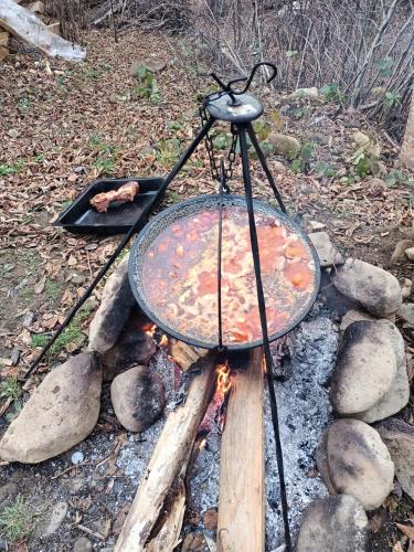 a pizza pan on top of a fire grill at Cabana lucia in Tarcău-Gheuca
