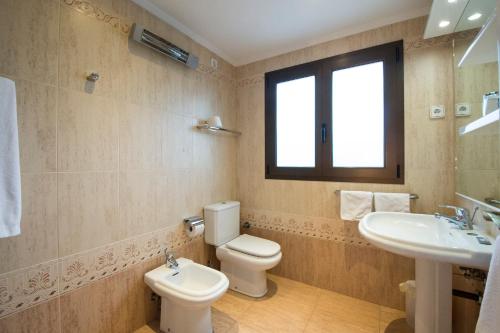 y baño con aseo y lavamanos. en Apartamentos Haus Am Meer, en Cambrils