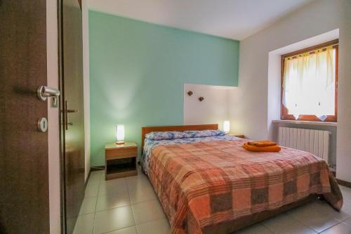 - une chambre avec un lit doté d'une couverture orange et d'une fenêtre dans l'établissement Cà Irene - Cà Battistoni, à Brenzone
