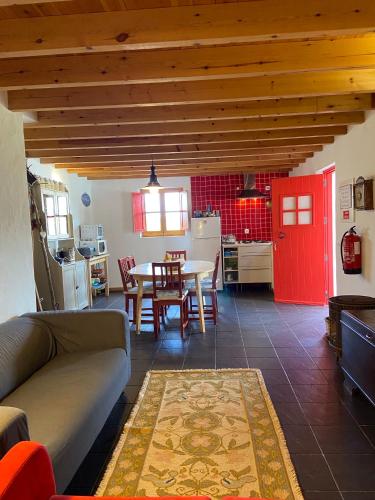 a living room with a table and a red door at Casa Pedralva in Vila do Bispo