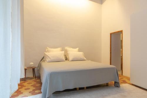 a bedroom with a bed with white sheets and pillows at Josep Sanxo de La Jordana 12 in Artá