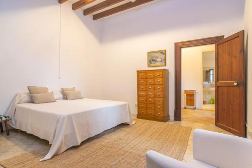a white bedroom with a bed and a dresser at Josep Sanxo de La Jordana 12 in Artá