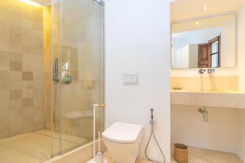 a bathroom with a toilet and a glass shower at Josep Sanxo de La Jordana 12 in Artá
