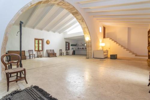 a large living room with an archway and a chair at Josep Sanxo de La Jordana 12 in Artá