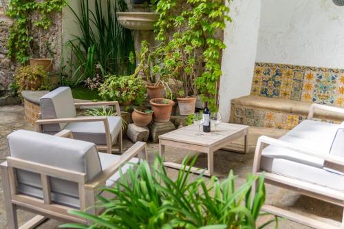 a patio with chairs and tables and potted plants at Josep Sanxo de La Jordana 12 in Artá