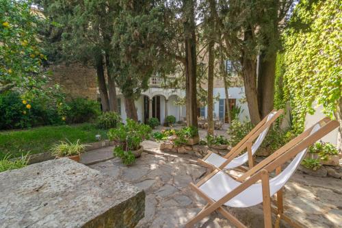 a wooden chair sitting on a stone table in a yard at Josep Sanxo de La Jordana 12 in Artá