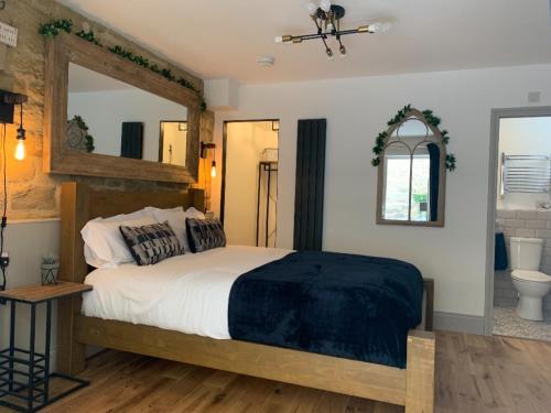 1 dormitorio con 1 cama grande y espejo en Castle View Bed and Breakfast en Morpeth