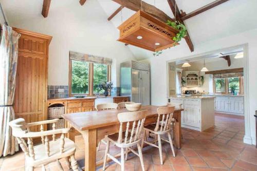 eine Küche mit einem Holztisch und Stühlen in der Unterkunft Stunning Country Farm House between Bristol & Bath in Bristol
