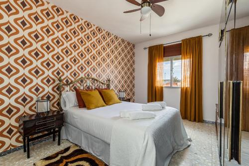 1 dormitorio con 1 cama con sábanas blancas y almohadas amarillas en BNBHolder La Casa de los Abuelos TITULCIA, en Titulcia