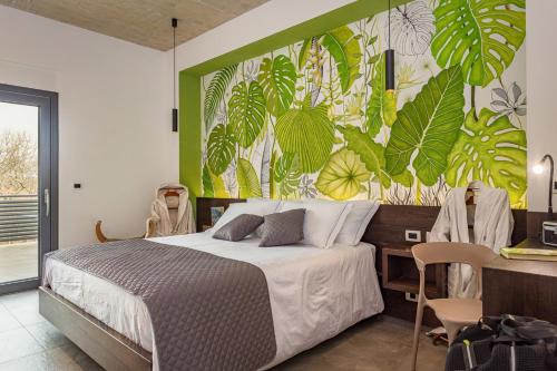 ein Schlafzimmer mit einem Bett und einer Wand mit Pflanzen in der Unterkunft BIJOU house with apartments in Vilanija