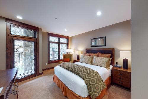 um quarto com uma cama, uma secretária e janelas em Northstar Lodge Luxury em Kingswood Estates