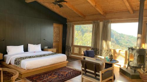 sypialnia z łóżkiem i dużym oknem w obiekcie Qayaam Gah w mieście Śrinagar