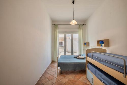 1 dormitorio con 2 literas y ventana en Casa Vacanze Kalocéri, en Torre dell'Orso