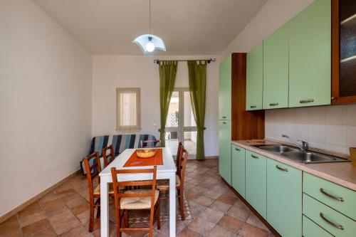 a kitchen with a table and chairs in a room at Casa Vacanze Kalocéri in Torre dell'Orso