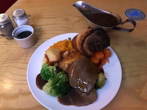 a plate of food with meat and vegetables on a table at Sutherlands Hotel in Gateshead