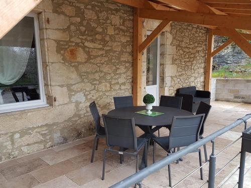 a black table and chairs on a patio at Maison de Charme l Etoile in Saint-Vincent-de-Cosse