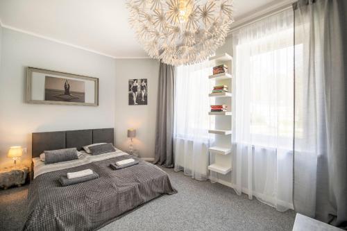 Un dormitorio con una cama grande y una lámpara de araña. en Apartament Boheme, en Lądek-Zdrój