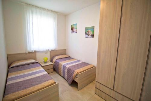 1 dormitorio con 2 camas y ventana en Cala Blu, en Lido di Jesolo