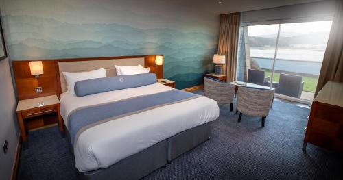 a hotel room with a large bed and a large window at The Quay Hotel and Spa in Conwy