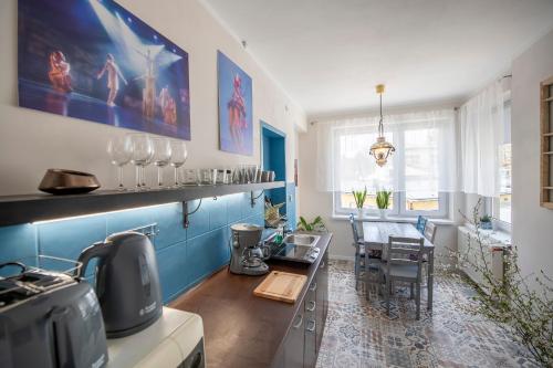 una cocina con paredes azules y blancas y una mesa en Apartament Boheme, en Lądek-Zdrój